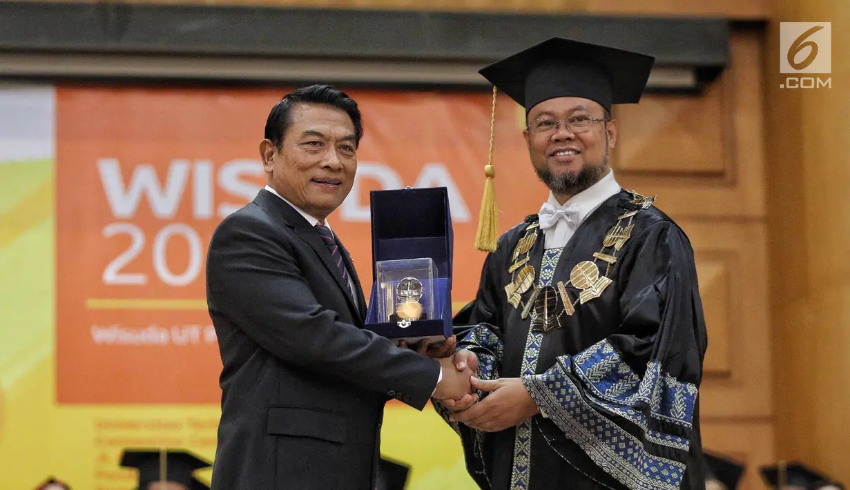 Rektor Universitas Terbuka Drs. Ojat Darojat, M.Bus., Ph.D memberikan cinderamata kepada Kepala Staf Kepresidenan Moeldoko usai memberikan orasi ilmiah saat wisuda Universitas Terbuka, Tangerang Selatan, Selasa (3/7). (Liputan6.com/Faizal Fanani)