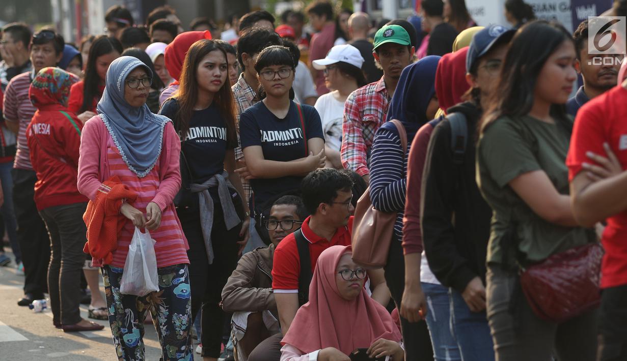 Calon penonton antre untuk mendapatkan tiket final bulu tangkis beregu putra di sekitar tiket boks di kawasan GBK, Jakarta, Rabu (22/8). Laga final bulu tangkis beregu putra mempertemukan Indonesia melawan China. (Liputan6.com/Helmi Fithriansyah)