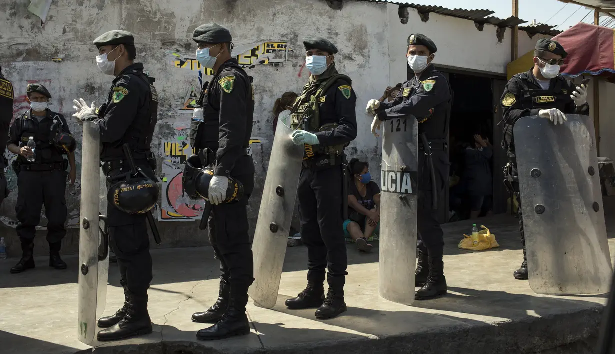 Polisi berjaga di luar Penjara Lurigancho saat protes narapidana di Lima, Peru, Selasa (28/4/2020). Narapidana mengeluhkan pihak berwenang tidak berbuat cukup untuk mencegah penyebaran COVID-19 dalam penjara. (AP Photo/Rodrigo Abd)