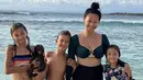 <p>Indah Kalalo bersama tiga anaknya mengenakan bikini two pieces. Dengan atasan bukini long sleeve dan bawahannya serba hitam. (@indahkalalo)</p>