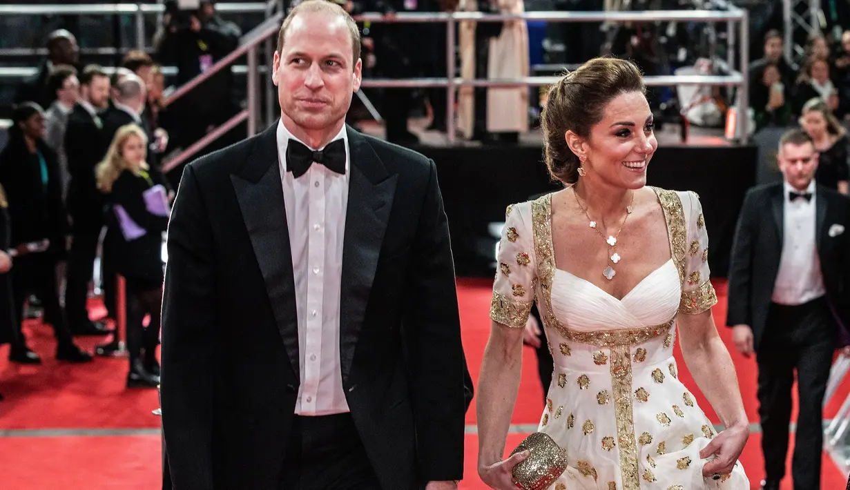 Pangeran William dan istrinya, Kate Middleton menghadiri acara BAFTA 2020 di Royal Albert Hall London pada 2 Februari 2020. Kate Middleton menjadi pusat perhatian di karpet merah dengan gaun putih beraksen emas rancangan salah satu label favoritnya, Alexander McQueen. (Jeff Gilbert/POOL/AFP)