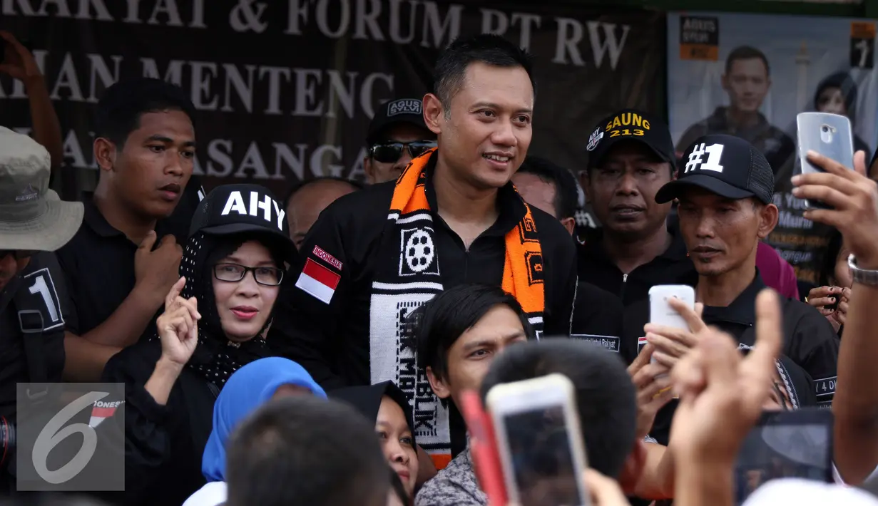 Cagub DKI Jakarta, Agus Harimurti Yudhoyono (tengah) berfoto bersama pendukungnya saat sosialisasi di Jalan Menteng Raya, Jakarta, Kamis (22/12). Agus bersosialisasi sambil berkeliling ke beberapa RW di kawasan tersebut. (Liputan6.com/Helmi Fithriansyah)