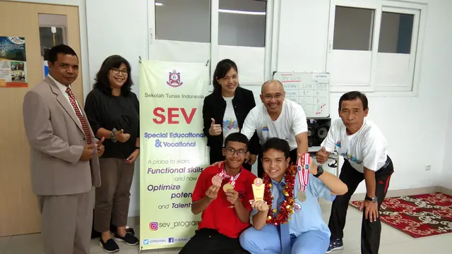Michael dan Ruben Rotty (baju biru), salah satu penyandang autisme yang juga mengikuti ASEAN Autism Games bersama guru-gurunya (Giovani Dio Prasasti/Liputan6.com)