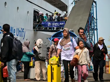 Para penumpang berjalan keluar untuk turun dari kapal di pelabuhan Perak, Surabaya, Jawa Timur pada Minggu 15 Maret 2026. Arus mudik di Pelabuhan Tanjung Perak, Surabaya, Jawa Timur, memasuki periode dengan jumlah penumpang yang signifikan. (JUNI KRISWANTO/AFP)
