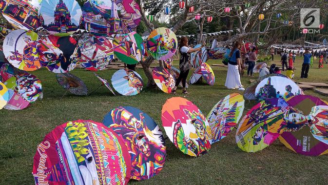 Pengunjung berpose di deretan payung selama Festival Payung Indonesia 2019 di Taman Garuda Mandala, Komplek Candi Prambanan, Kabupaten Klaten, Sabtu ( 7/9/2019). Festival Payung Indonesia 2019 telah berlangsung ke enam kalinya. (Liputan6.com/Gholib)