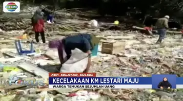 Warga Pulau Selayar, mengais barang-barang korban KM Lestari Maju yang terbawa ke pinggir pantai.