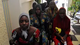 Gadis-gadis sekolah Chibok yang baru saja dibebaskan dari penahanan Boko Haram menunggu untuk bertemu Presiden Muhammadu Buhari di Abuja, Nigeria (7/5). Sebanyak 82 dari 276 siswa perempuan Chibok berhasil dibebaskan. (AP Photo/Olamikan Gbemiga)