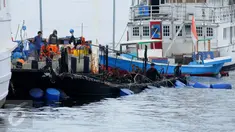Sejumlah drum yang diisi helium dipasang ke sekeliling bangkai kapal Zahro Express di Pelabuhan Muara Angke, Jakarta, Rabu (4/1). Petugas mulai mengangkat bangkai kapal Zahro Express untuk mempermudah penyelidikan KNKT. (Liputan6.com/Gempur M Surya)