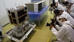 Sejumlah wartawan mengabadikan gambar Diwata - 1 di JAXA Tsukuba Space Center, Jepang, (13/1). Alat ini dirancang oleh orang Filipina yang berkerjasama dengan badan antariksa Jepang. (REUTERS / Yuya Shino)