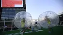 Para pemain mengolah si kulit bundar dari dalam sebuah gelembung berbentuk bola di Beijing, Kamis (10/7/14). (REUTERS/Kim Kyung-Hoon)