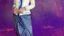 Maudy Ayunda tampil mengenakan kebaya putih lengan panjang yang dipadukan kain lilit warna biru. [Instagram/@maudyayunda]