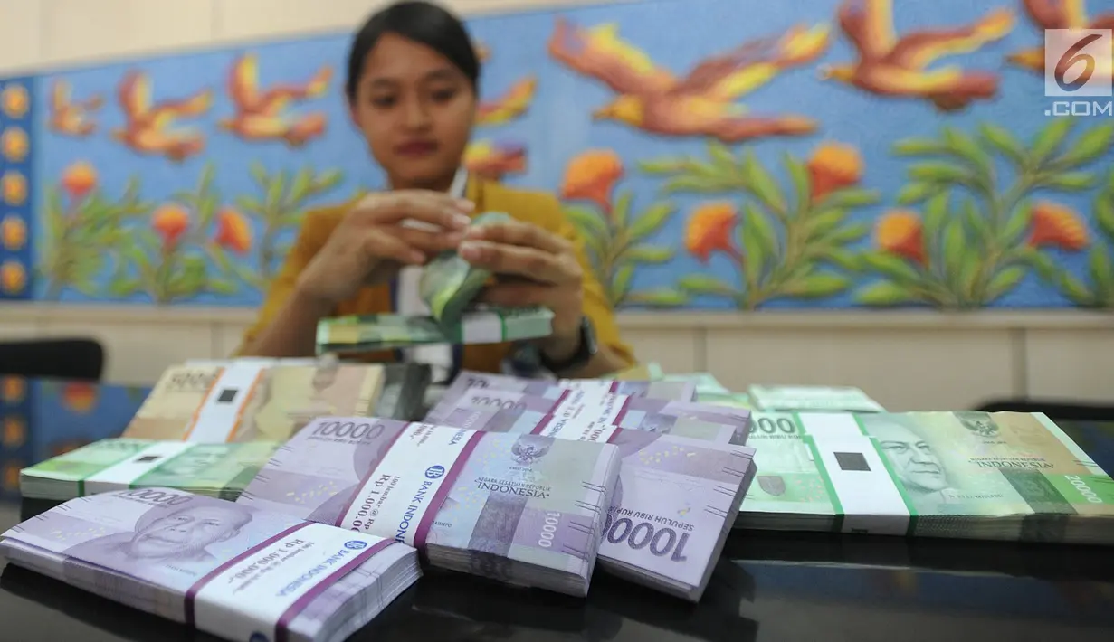 Teller menghitung uang pecahan kecil di kantor cabang Bank BJB di Melawai, Jakarta (7/6). Mengantisipasi kebutuhan dana masyarakat di bulan Ramadan dan Lebaran, pemerintah telah mengalokasikan uang tunai sebesar Rp 188,2 Triliun. (Merdeka.com/Arie Basuki)