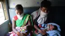 Pasangan buruh migran menggendong bayi ketika menaiki kereta khusus menuju rumah mereka saat masa karantina wilayah (lockdown) nasional diterapkan demi mencegah penyebaran COVID-19 di Jalandhar, Negara Bagian Punjab, India utara, (5//5/2020). (Xinhua/Stringer)
