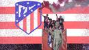 Para pemain Atletico Madrid merayakan gelar Liga Europa dengan menaiki air mancur Neptune di Madrid, Jumat (18/5/2018). Kota Madrid menjadi merah saat perayaan gelar juara Atletico. (AFP/Javier Soriano)