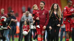 Diogo Jota menggendong anak beserta istrinya di Stadion Anfield pada laga terakhir Liverpool di Liga Inggris musim 2024/2025. (Paul ELLIS / AFP)