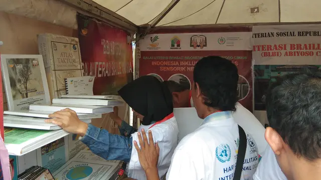 Seorang pengunjung "melihat" buku dan CD yang diterbitkan oleh BLBI Abiyoso (Liputan6.com/Giovani Dio Prasasti)