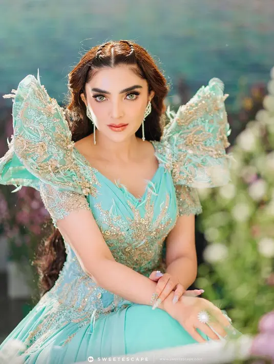 Penampilan Ashanty bak dewi dalam balutan gaun biru kehijauan yang sangat cantik. Ia bahkan memakai wig panjang ikal berwarna merah dan makeup bold yang pas. Foto: Instagram.