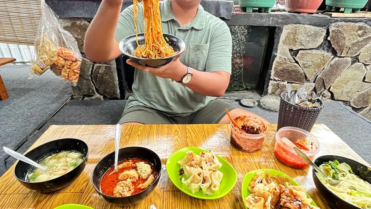 Salah satu pengunjung tengah menikmati sajian jajanan baso aci kakang, di jalan Merdek, Kerkof, Garut, Jawa Barat. (Liputan6.com/Jayadi Supriadin)