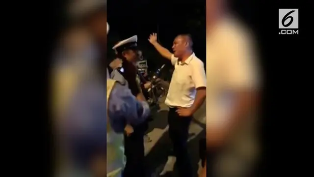 Seorang pria di China menari ketika ditilang polisi. Ia diduga dalam pengaruh alkohol ketika sedang mengemudi.