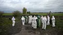 Para relawan bersiap-siap untuk mengumpulkan bangkai burung bangau yang diduga mati akibat flu burung di sebuah ladang dekat Linum, Jerman, pada 24 Oktober 2025. (RALF HIRSCHBERGER/AFP)