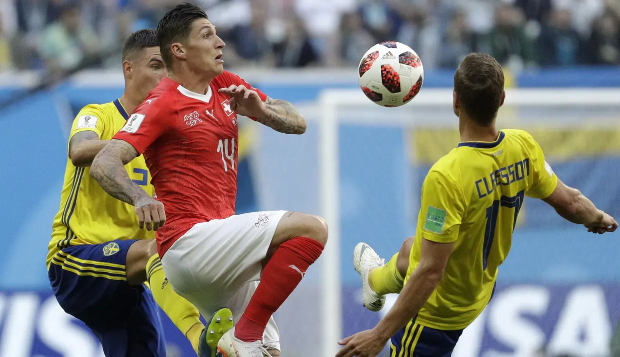 Gelandang Swiss, Denis Zakaria, berusaha melewati gelandang Swedia, Viktor Claesson, pada babak 16 besar Piala Dunia di Stadion St Petersburg, St Petersburg, Selasa (3/7/2018). Swedia menang 1-0 atas Swiss. (AP/Gregorio Borgia)
