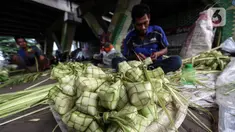 Perajin membuat kulit ketupat dari janur saat berdagang di Pesanggrahan, Jakarta, Kamis (20/4/2023). (Liputan6.com/Johan Tallo)
