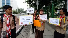 Sejumlah anggota Pramuka yang tergabung dalam Askara melakukan aksi peduli pedestrian di sekitar Jalan Medan Merdeka Timur, Jakarta, Jumat (17/3). Mereka menghimbau pengguna motor untuk tidak melewati trotoar jalan. (Liputan6.com/Helmi Fithriansyah)