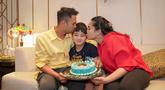 Raffi Ahmad, Nagita Slavina mencium Rafathar yang tengah memegang kue ulang tahunnya.