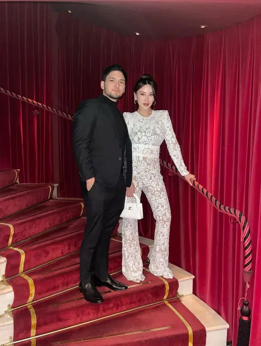 Tahun baru bareng suami, Kezia tampil bergaya dengan jumpsuit brukat semi transparan berwarna putih. Outfitnya terlihat serasi dengan Chanel Bag yang dijinjingnya. [@keziatoemion]