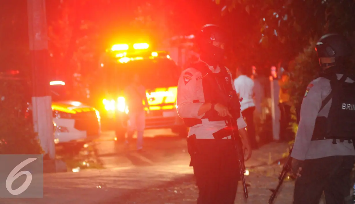 Petugas mengawal ambulan yang berisi mayat terduga teroris di Setu, Tangerang Selatan, Banten, Rabu (21/12). Densus 88 terlibat baku tembak yang akhirnya menewaskan tiga orang terduga teroris. (Liputan6.com/Helmi Afandi)
