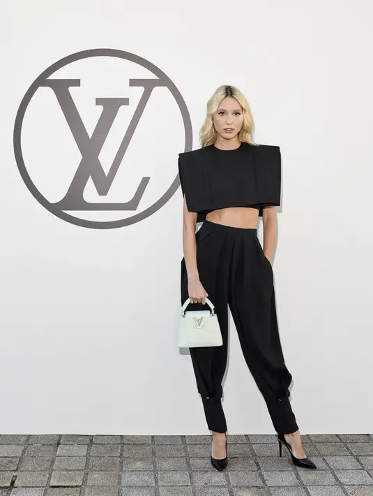 Anggota kerajaan Yunani, Princess Olympia hadir di pertunjukkan Louis Vuiton dengan outfit yang sederhana. Hanya memadukan crop top vest bewarna hitam dan celana aladin yang modern. (Louis Vuitton)