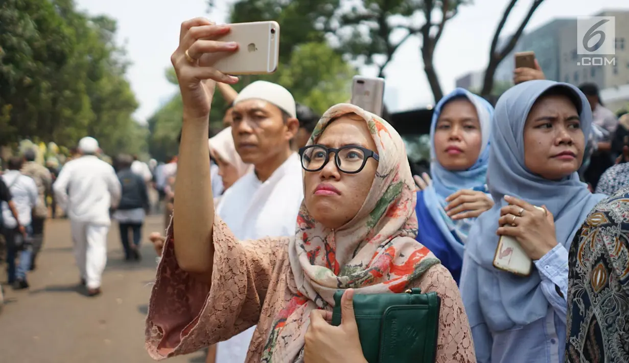 Warga memadati jalan di sekitar rumah duka Presiden ke-3 RI BJ Habibie di kawasan Kuningan, Jakarta, Kamis (12/9/2019). Meninggalnya BJ Habibie menarik simpatik masyarakat untuk datang mengantarkan kepergiaannya yang dimakamkan secara militer di TMP Kalibata, Jakarta Selatan. (Liputan6.com/Immanuel