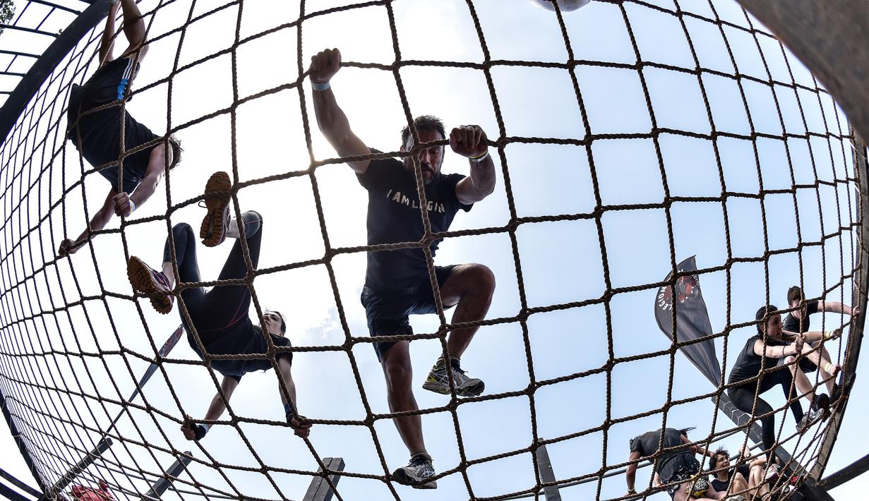 Peserta lomba melewati jaring saat mengikuti "Legion Run" di Roma, Italia, Sabtu (13/4). Peserta harus melewati rintangan seperti dari lumpur, es dan kawat berduri dengan jarak tempuh 5 kilometer. (AFP PHOTO / Andreas SOLARO)