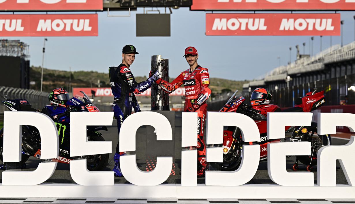 Pembalap Ducati, Francesco Bagnaia (kanan) dan pembalap Yamaha, Fabio Quartararo melakukan jabat tangan jelang seri terakhir MotoGP Valencia 2022 di Sirkuit Ricardo Tormo, Jumat (3/11/2022). (AFP/Javier Soriano)