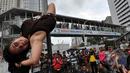 Tiang rambu lalu lintas menjadi arena aksi dari pegiat 'Pole Dance'  di Bundaran HI, Jakarta, Minggu (18/1/2015). (Liputan6.com/Miftahul Hayat)