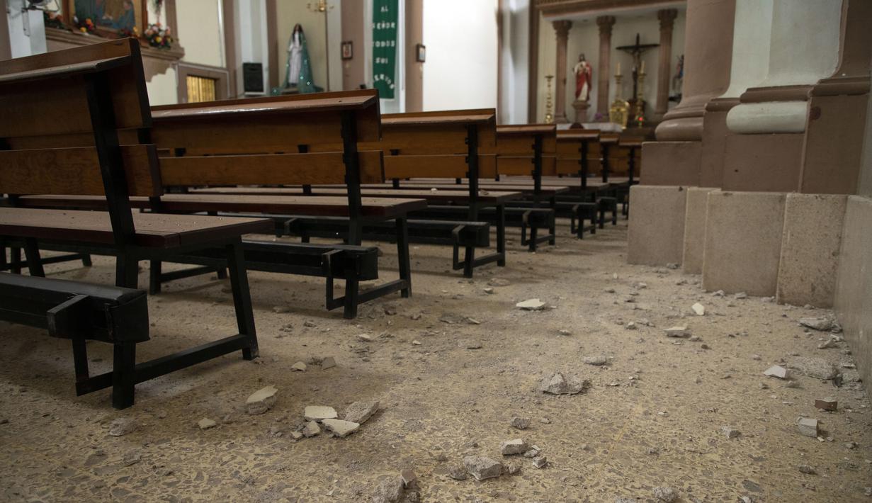 Puing-puing menutupi lantai sebuah gereja sehari setelah gempa bumi di Coalcoman, negara bagian Michoacan, Meksiko, Selasa (20/9/2022). Dua orang tewas dan puluhan bangunan rusak oleh gempa berkekuatan Magnitudo 7,6 yang mengguncang Meksiko pada peringatan dua gempa dahsyat, kata pihak berwenang Selasa. (AP Photo/Armando Solis)