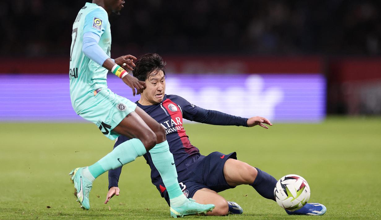 Pemain Paris Saint-Germain, Lee Kang-in, berusaha merebut bola dari pemain Montpellier, Falaye Sacko, pada laga Liga Prancis di Stadion Parc des Princes, Sabtu (4/11/2023). (AFP/Franck Fife)