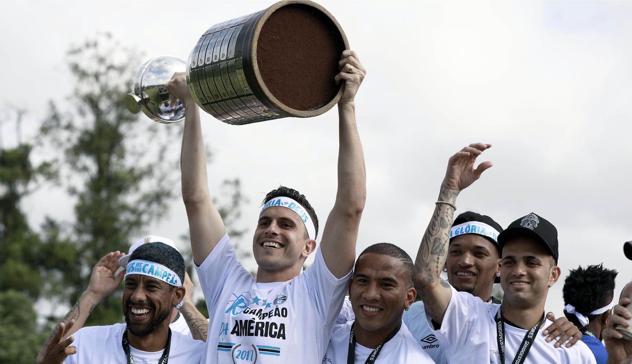 Kiper Gremio, Marcelo Grohe, mengangkat piala Copa Libertadores saat pawai di Porto Alegre, Brasil, Kamis (30/11/2017). Gremio menjadi juara Copa Libertadores setelah mengalahkan Lanus dengan skor agregat 3-1. (AFP/Itamar Aguiar)