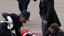 Polisi bergegas menolong seorang anggota Household Cavalry yang pingsan saat berada dalam posisi untuk upacara pertama Raja untuk Order of the Garter sebagai raja. (AP Photo/Kirsty Wigglesworth, Pool)