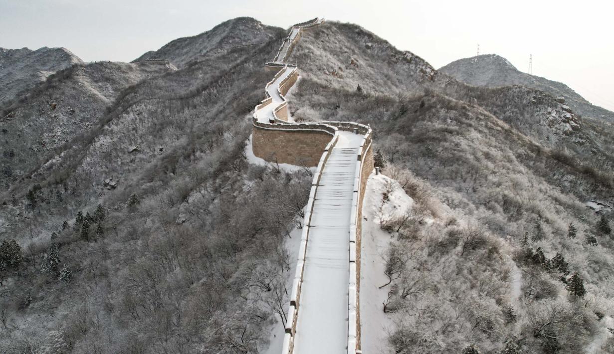 Hujan salju yang terjadi semalaman menyebabkan Tembok Besar Cina tertutup salju. (GREG BAKER/AFP)