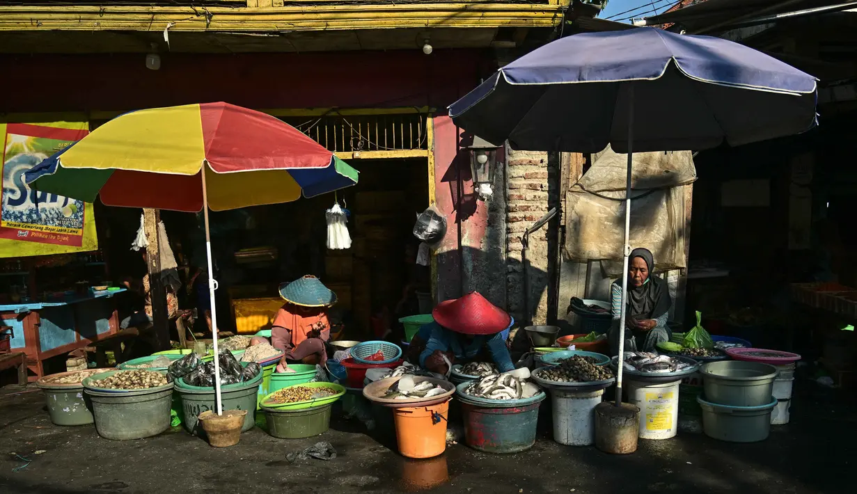Para pedagang menjual makanan laut segar di sebuah pasar ikan tradisional di Surabaya, Jawa Timur, pada 9 Oktober 2025. (Juni Kriswanto/AFP)