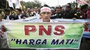 Pengunjuk rasa membentangkan spanduk bertuliskan "PNS Harga Mati" saat berunjuk rasa di depan Istana Merdeka, Jakarta, Rabu (10/2). Guru honorer dari seluruh Indonesia itu menuntut Pemerintah agar mengangkat mereka sebagai PNS (Liputan6.com/Faizal Fanani)