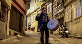 Penabuh gendang Turki, Hakan Ozbingol, memainkan gendang dan menyanyikan lagu-lagu tradisional di jalanan Istanbul, untuk membangunkan umat Muslim untuk sahur, yaitu makan malam Ramadan, pada 24 Februari 2026. Turki memiliki tradisi menabuh drum di jalan-jalan untuk membangunkan sahur sebelum memulai puasa di bulan suci Ramadan. (Yasin AKGUL/AFP)