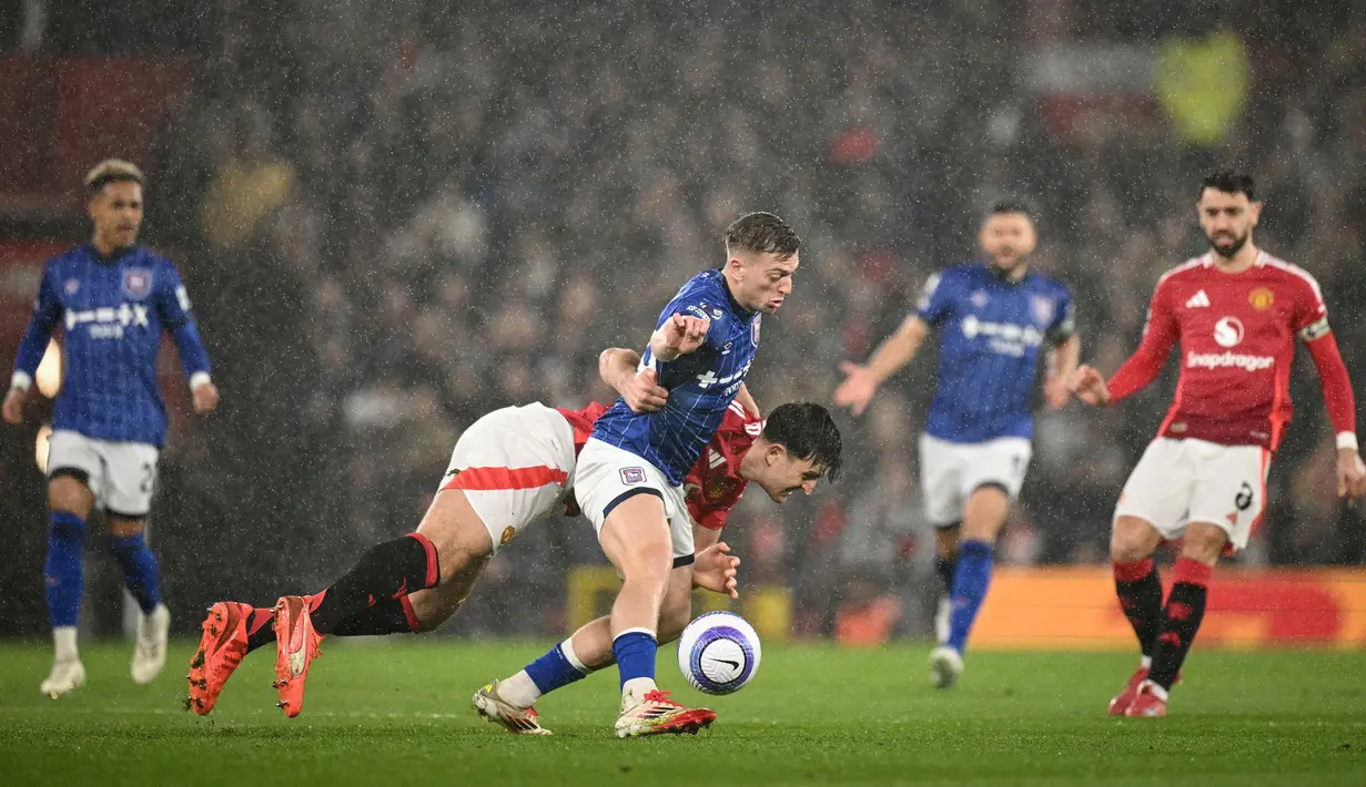 <p>Pemain Manchester United, Harry Maguire, berebut bola dengan pemain Ipswich Town, Liam Delap, dalam laga lanjutan Liga Inggris 2024/2025 di Old Trafford, Manchester, Inggris, Kamis (27/02/2025). (AFP/Oli Scarff)</p>