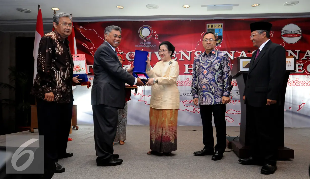 Ketua Aliansi Kebangsaan Pontjo Sutowo (kedua kiri) memberikan cenderamata kepada Ketua Umum PDIP, Megawati Soekarnoputri (tengah) usai pembukaan Konvensi Nasional tentang Haluan Negara di JCC, Jakarta, Rabu (30/3/2016). (Liputan6.com/Helmi Fithriansyah)