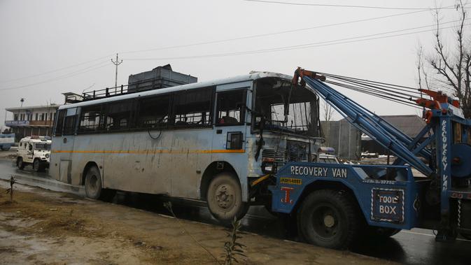 Sebuah bus yang rusak dibawa setelah ledakan bom mobil di Lethpora di distrik Pulwama, Kashmir, India (14/2). Menurut kesaksian dari seorang perwira polisi mobil bermuatan bom tersebut meledak usai menabrak konvoi pasukan CRPF. (AFP Photo/STR)