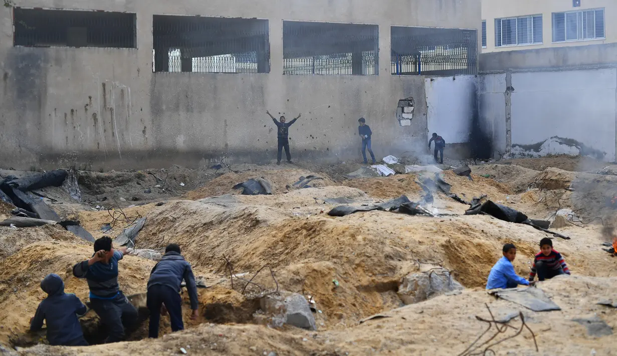 Anak-anak bermain permainan "Arab dan Yahudi" di luar sekolah di Kota Gaza (20/2). Saat istirahat sekolah, anak-anak bermain permainan "Arab dan Yahudi" dengan membakar kardus dan saling melempar bola pasir. (Reuters/Dylan Martinez)