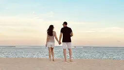 Cut Tari menikmati liburan ke pantai bersama suami dengan mesra. Saling bergandengan tangan dan saling pandang membuat momen kebersamaan mereka bikin baper. Netizen pun mendoakan keduanya selalu harmonis. (Liputan6.com/IG/cuttaryofficial)