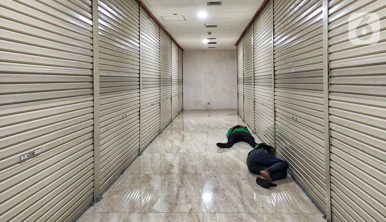 Dua pria tidur di depan toko di pusat perbelanjaan Ambasador, Jakarta, Rabu (23/6/2021). Pemerintah memperkuat Pemberlakuan Pembatasan Kegiatan Masyarakat (PPKM) skala mikro, di antaranya pembatasan jam operasional pusat perbelanjaan yang dibatasi sampai pukul 20.00WIB. (Liputan6.com/Johan Tallo)