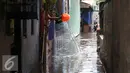Seorang warga menguras air yang masuk kedalam rumahnya akibat banjir di kawasan Jatayu, Jakarta, Senin (21/11). Banjir disebabkan tingginya curah hujan dan buruknya saluran air serta meluapnya Kali Pesanggrahan. (Liputan6.com/Gempur M. Surya)